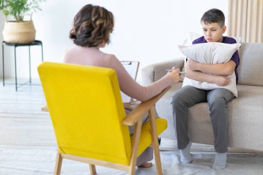 Tanınmayan kadın psikoterapist genç kızlarla terapi yapıyor. Okul psikoloğu. Hüsrana uğramış çocuk yastığa sarılıyor..