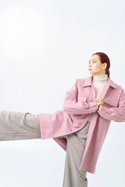 Азійка Рудим Волоссям Одягає Рожеве Пальто Сірі Штани Нога Піднімається — стокове фото