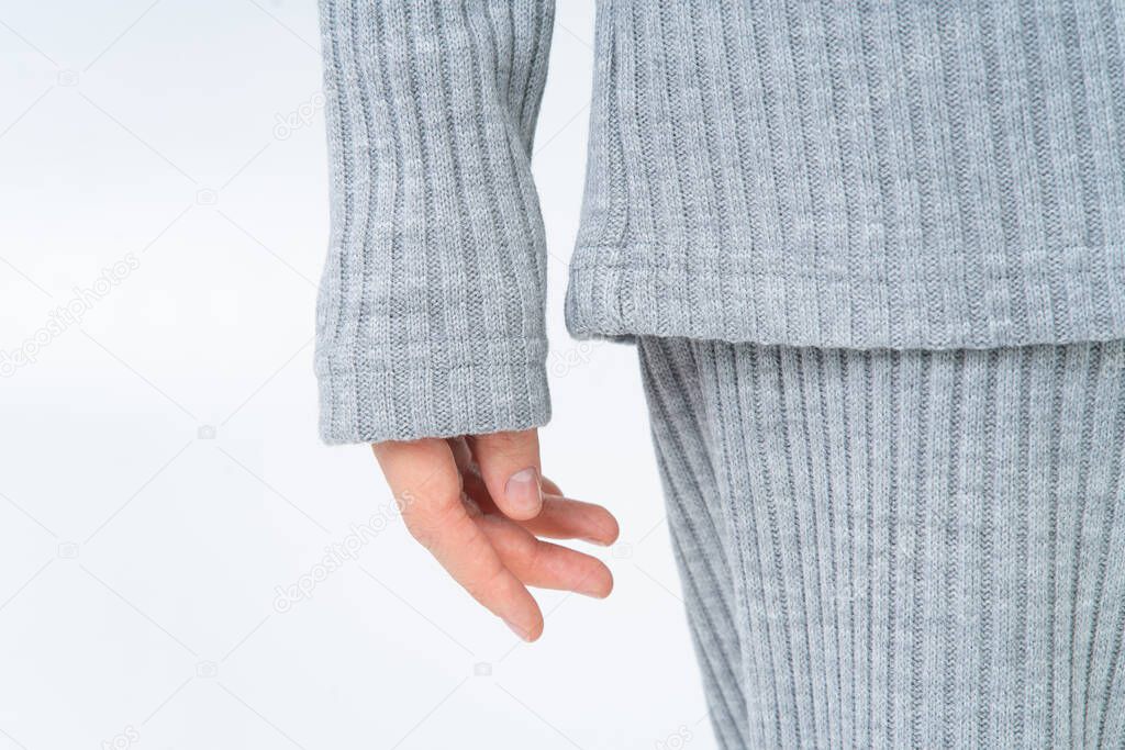 A woman in a warm cozy suit of gray cashmere pajamas. Close-up of the arms and sleeves. White background. Without a face.