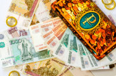 Orosz pénz fekszik egy arany fából készült malacperselyben. A finanszírozás, a befektetés, a készpénz és a megtakarítások fogalma