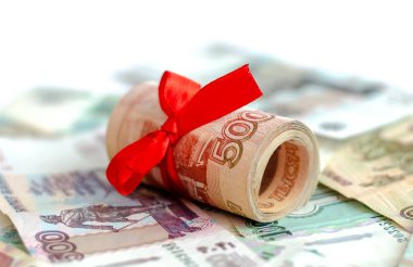 Rus parası, Rus banknotlarının üzerinde duran, yüzey değeri 5000 ruble olan kırmızı saten bir kurdeleyle bağlanmış. Finans, yatırım, tasarruf ve nakit kavramı.