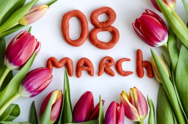 Bir buket lale ve 8 Mart 'ta plastik harflerden yapılmış bir yazı. Tatil kartı