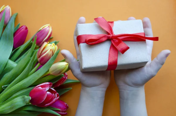 Ein Strauß Tulpen Ein Geschenk Mit Einem Roten Satinband Kinderhänden — Stockfoto