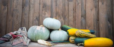 Birçok kabak ve kabak kırsal bir evin ahşap duvarında yatıyor..