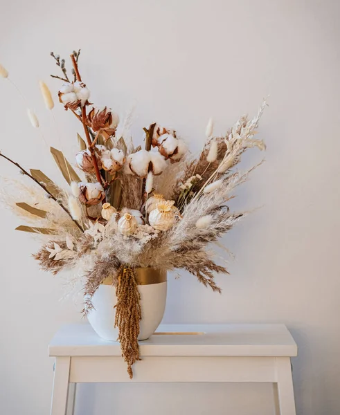 Flores secas en jarrones sobre mesa de madera sobre fondo blanco concepto  de floristería
