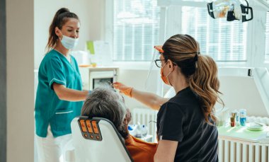 Dişçi Kliniğinde İsimsiz Olgun Bir Adam Bir Diş Deliğini Bileşikle Doldurmak İçin Diş Tedavisini Aldı