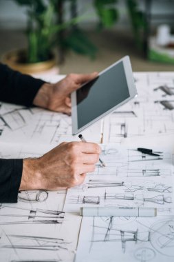 Tasarımcı Elleri 'nin, Tasarımcı El Çizimi ve Dijital Tableti Ofisinde Tutma Fotoğrafını Kapatın. Tanımlanamayan mobilya tasarımcısı dijital tabletini kullanırken çizim tasarımı yapıyor ve masasında oturuyor..
