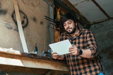 Gülümseyen Marangoz Atölyesinde Dijital Tablet Kullanıyor