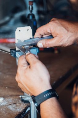 Atölyesinde çalışan isimsiz bir marangoz. Yakından çekilen fotoğrafta insan eli, daha kalibre tahtaları ölçer..