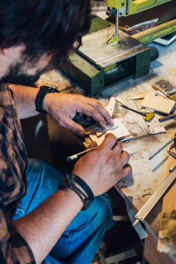 Atölyesinde çalışan tanınmayan bir marangoz. Tahtaya kalem çizerken erkek eli fotoğrafını çek.. 