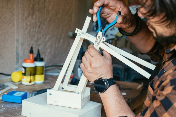Sütunları tutan ve atölyesinde robotik kol yapan adamın yakın fotoğrafını çek.