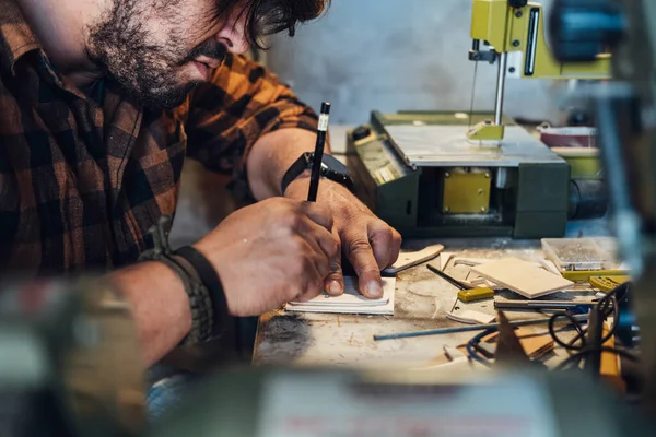 Atölyesinde çalışan tanınmayan bir marangoz. Tahtaya kalem çizerken erkek eli fotoğrafını çek.. 