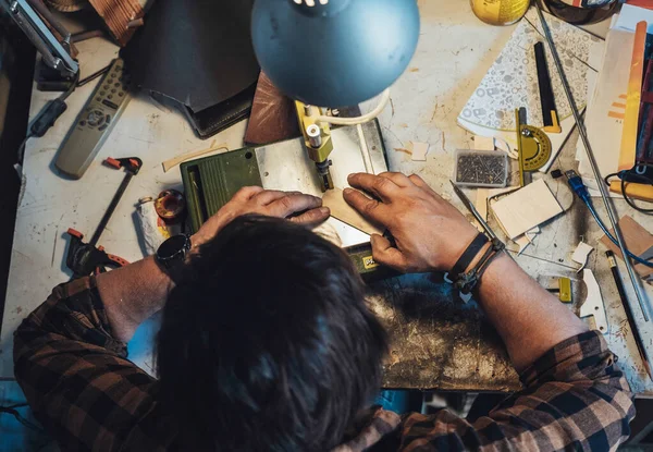 Atölyesinde çalışan isimsiz bir marangozun resmi. Garajındaki testereyle tahta kesen tanınmayan bir adamın masa üstü görüntüsü..