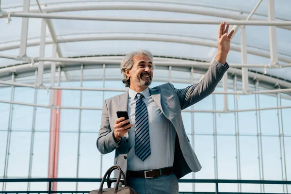 Hombre Negocios Sonriente Saludando Alguien Mientras Espera Vuelo Aeropuerto Vista — Foto de Stock