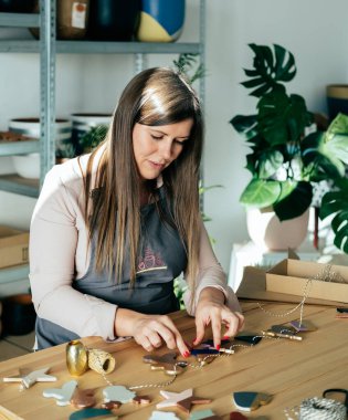 Önlüklü Mutlu Kadın, Clay 'in Noel süslerini atölyesinde ziyan ediyor.