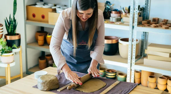 Mutlu kadın atölyesinde Clay 'i şekillendiriyor.