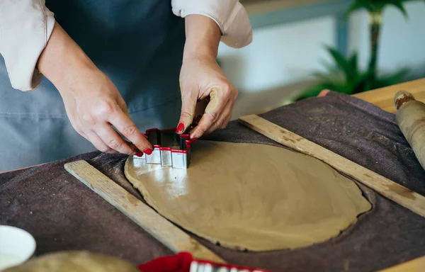Kadın Elleri 'nin, atölyesinde Clay' in Noel süslerini yaparken çekilmiş yakın bir fotoğrafı.