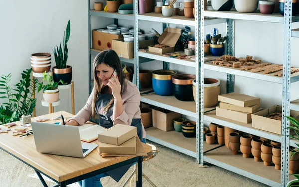 Happy Woman Potter Rozhovoru Mobilním Telefonu Zákazníkem Při Přípravě Balíčků — Stock fotografie