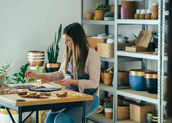 Happy Woman Artisan Manufacturing Handmade Ceramics Christmas Decoration While Sitting — Stock Photo, Image