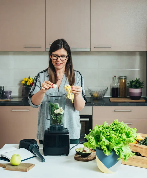 Glimlachende Vrouw Maken Van Groene Smoothie Voor Het Ontbijt Thuis — Stockfoto