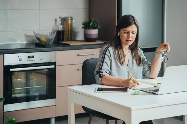 Mulher Negócios Sorridente Sentada Mesa Cozinha Escrevendo Notas Caderno Enquanto — Fotografia de Stock