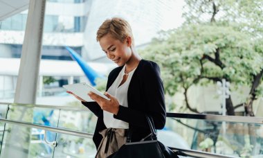 Smiling Business Woman Using Digital Tablet While Standing At Office Terrace