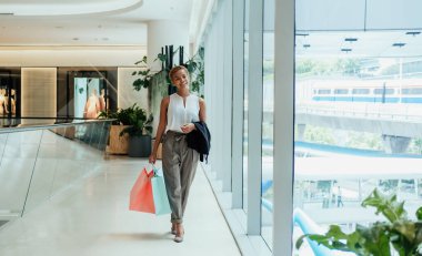 Smiling Woman Carrying Shopping Bags In The Mall