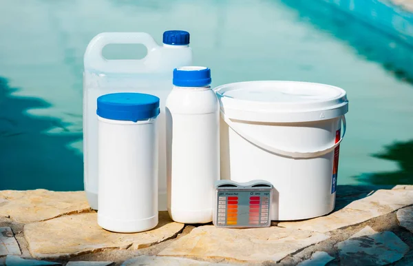 Close up photo of equipment for testing the quality of pool water and chemical cleaning products at the edge of swimming pool