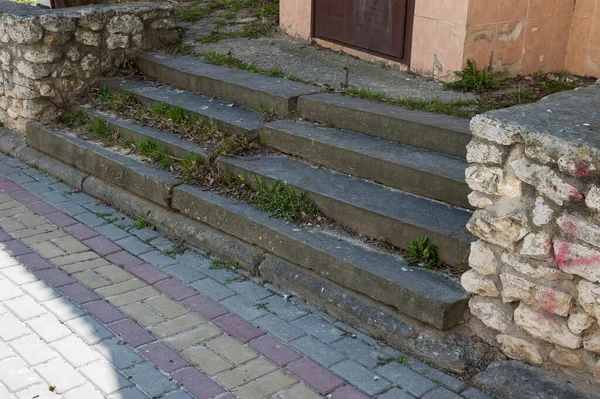 old grass-covered concrete steps, paved walkway