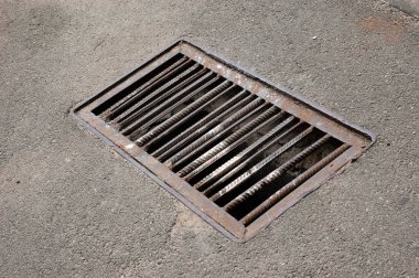Asfalt yolda paslı bir ızgara.