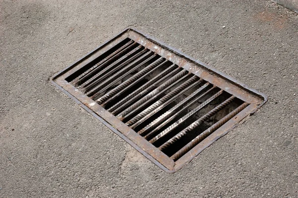 Asfalt yolda paslı bir ızgara.