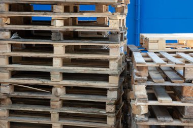 Mavi duvara karşı ahşap paletler yığını