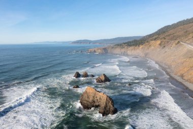 Pasifik Okyanusu, Fort Bragg 'ın kuzeyindeki Kuzey Kaliforniya' nın engebeli kıyılarına vurur. Pasifik Sahil Otoyolu Mendocino ilçesindeki bu bölge boyunca uzanıyor..