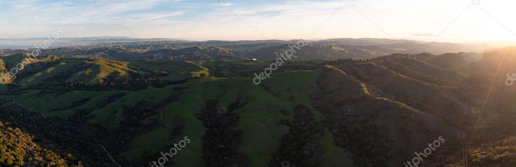 Early morning sunlight shines on the green hills of the east bay, near San Francisco Bay. These hills in California are dry much of the year but turn green durning wet, winter months.