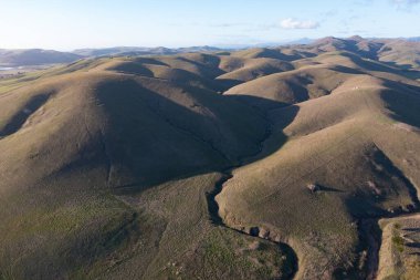 Afternoon sunlight shines on coastal hills in Central California, not far from Morro Bay. This scenic region, between Los Angeles and San Francisco, is a popular tourist destination.