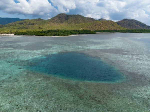A deep blue hole is found on a shallow reef in Indonesia.