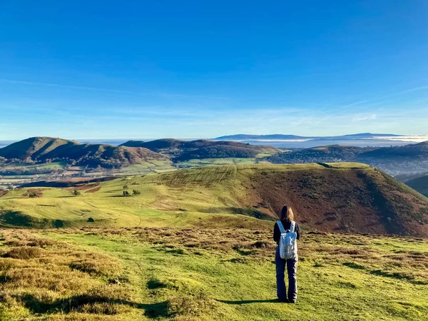 Tepelerin manzarası ve yürüyen kız.