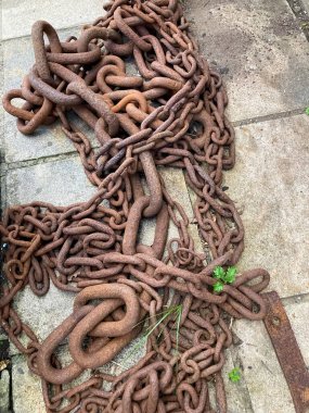 Çapa zincirlerinin paslı halkaları kaldırımda..