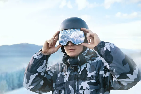 Lyžař Pozadí Modré Oblohy Drží Lyžařské Brýle Odrazem Zasněžených Hor — Stock fotografie