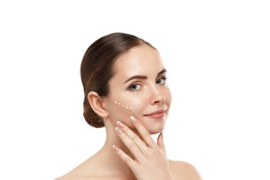 Taze derisi ve yüz kremi sürmüş uzun kirpikli güzellik modeli. Gençlik ve Deri Bakımı Konsepti. Spa ve Sağlık. 