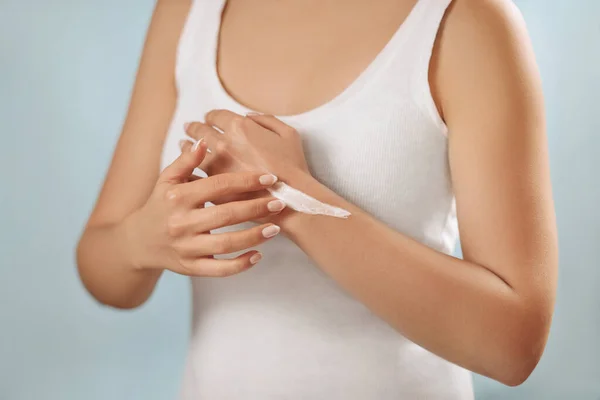 手部皮肤护理 女性手用乳霜 乳液的近距离接触 美丽的女人的手与法国指甲应用化妆品手霜软滑健康的皮肤 美体护理概念 — 图库照片