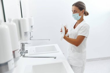 Hijyen, sağlık hizmetleri. Kadın doktor ya da hemşire portresi hastanede ellerini yıkadıktan sonra kağıt mendille kurutuyor.