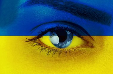 Ukrayna bayrağı renginde bir kadın. Kadın yüzünün üzerinde Ukrayna bayrağı