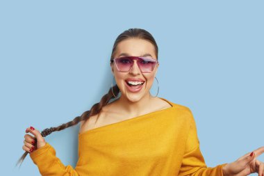 Mavi duvarda izole edilmiş güzel bir kadının portresi.