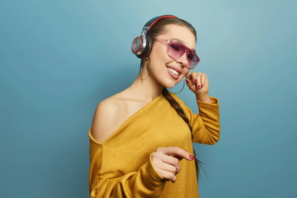 Junge Frau Tanzt Beim Musikhören Mit Kopfhörern Vor Blauem Hintergrund — Stockfoto