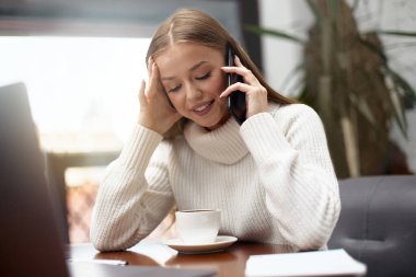 Kadın arıyor, konuşuyor ve bir şey soruyor, dizüstü bilgisayar kullanıyor.