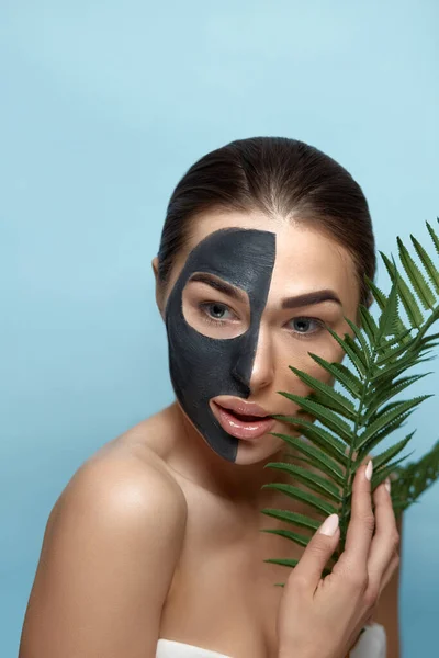 美女面对护肤面罩 一个脸上戴着黑色粘土面具的漂亮女性的画像 温泉治疗 带保湿霜面罩的女模 — 图库照片
