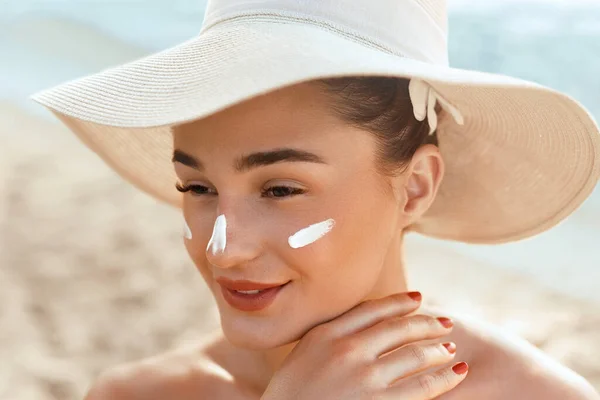 Suncream. Suntan Lotion Beautiful Woman Applying on beautiful on Face. Sunscreen Solar Cream. Skin care. Sun protection.The Girl Uses  Moisturizer Sunblock