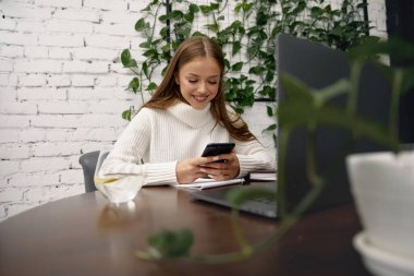 Genç ve güzel bir kadın iş için akıllı telefon kullanıyor, online alışveriş, para transferi, finans, internet bankacılığı