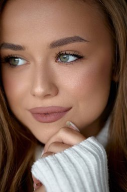 Cilt bakımı. Güzel yüzlü kadın sağlıklı yüz portresine dokunuyor. Doğal makyajla cildine dokunan güzel, gülümseyen kız modeli..